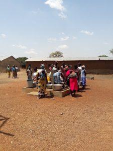 Mujeres y niñas cogiendo agua en las instalaciones
