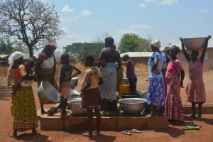 Imagen de mujeres y niñas cogiendo agua en una de las instalaciones de grifo