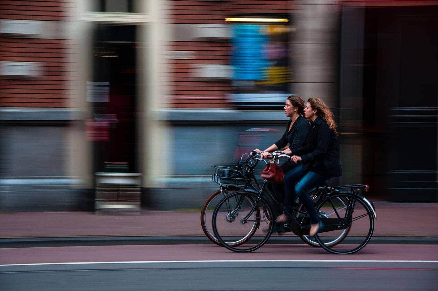 Image of two women riding a bicycle