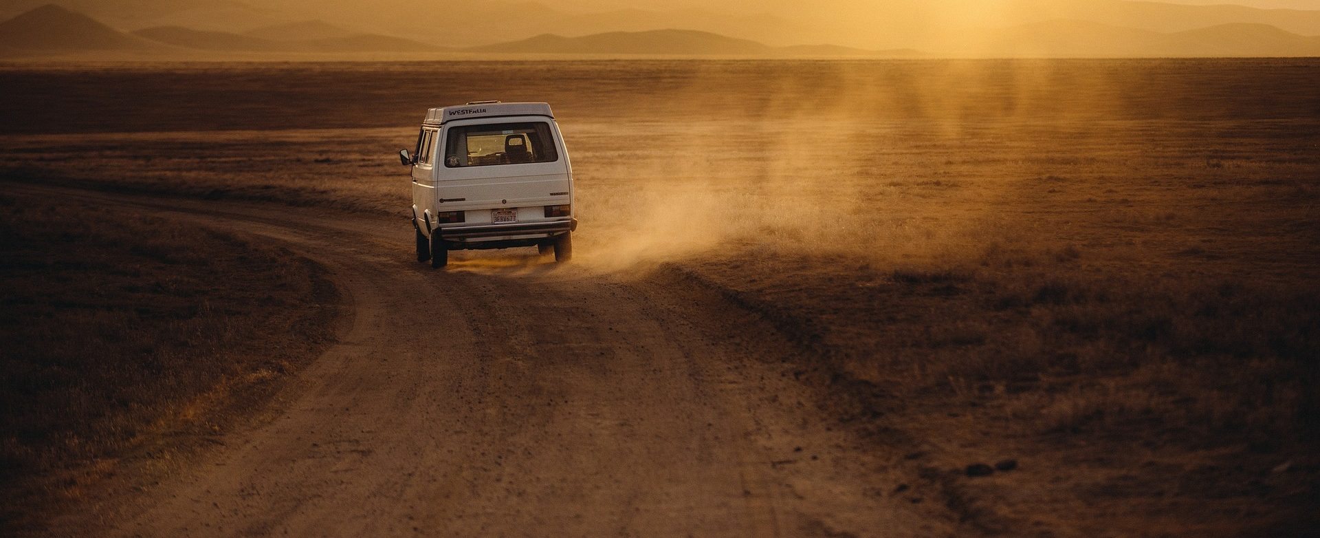 White color van crossing a lonely and desert road