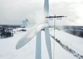 Drone removing snow from a wind turbine
