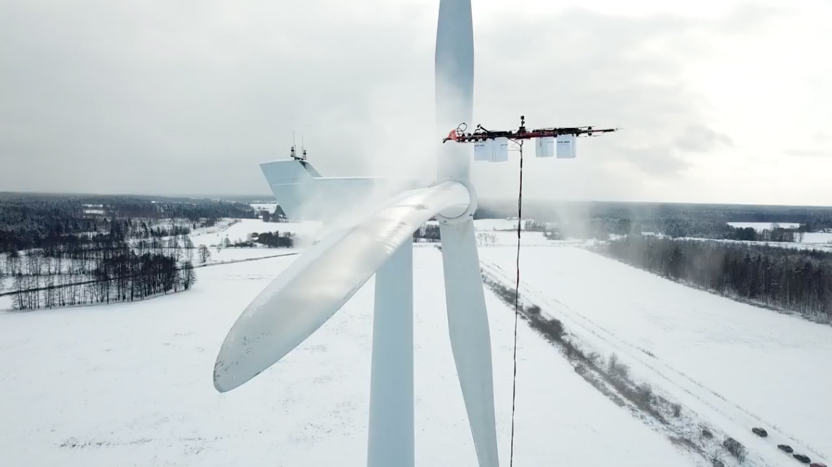 Drone removing snow from a wind turbine