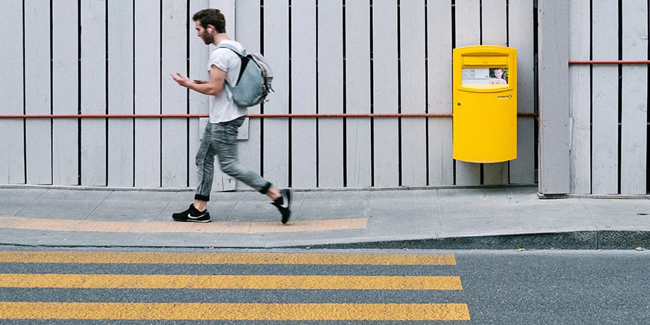 Young man walking near a zebra crossing