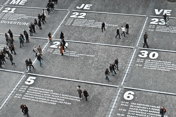  people walking between days and hours marked on the floor like a calendar