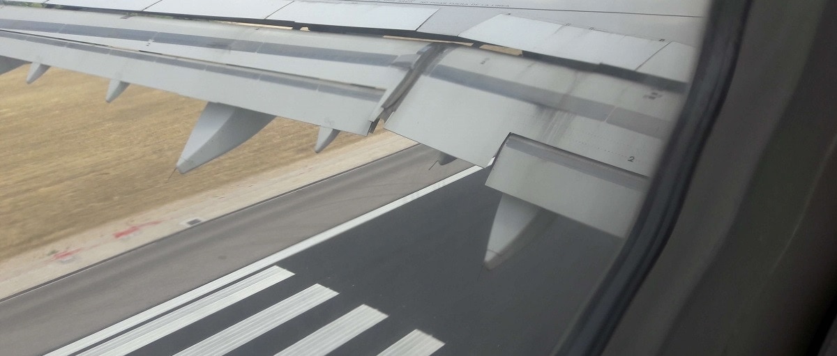 Image of the wing of an airplane and the track seen from the window