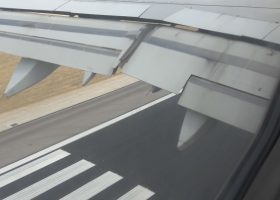 Imagen del ala de un avión y la pista vistas desde la ventanilla