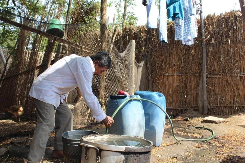  Image of a man using the hose that supplies running water