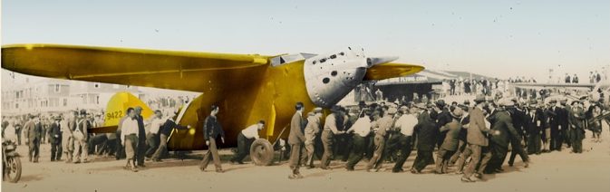 Imagen del aterrizaje del avion Pajaro Amarillo en la playa de oyambre y un moton de personas rodean al aparato