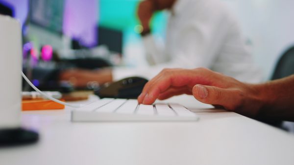 photo of a person's hand typing on a computer