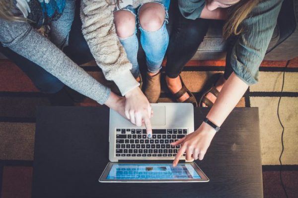 Aerial photo of a three girls in front of a laptop