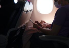 Persona usando la mascarilla dentro de un avión