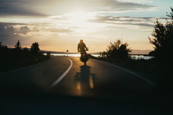 a man riding a motorcycle in the sunset