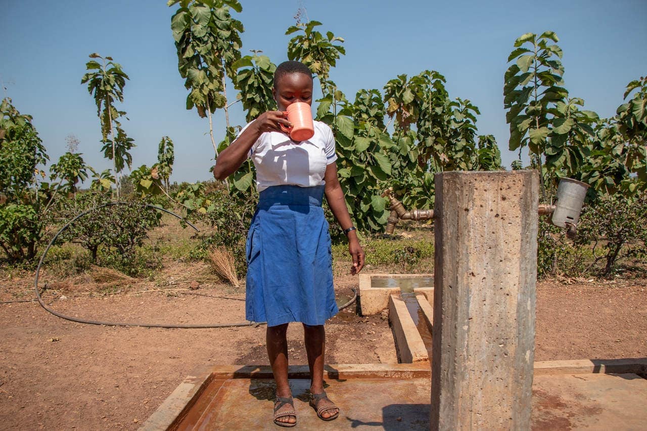 Girl drinking potable water at the village