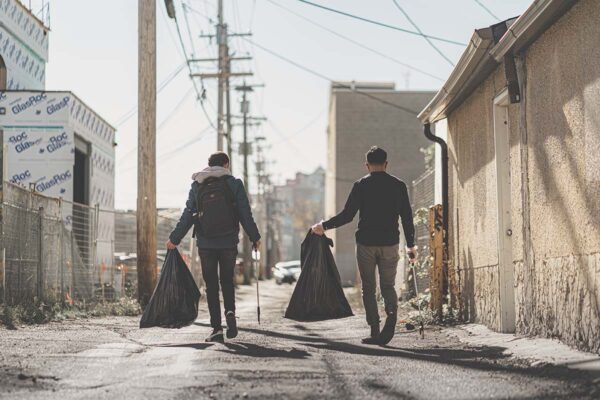 Two young men collect garbage during a walk in Chinatown