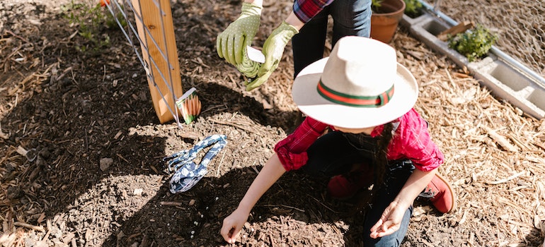 Child planting seeds in an eco-friendly garden.