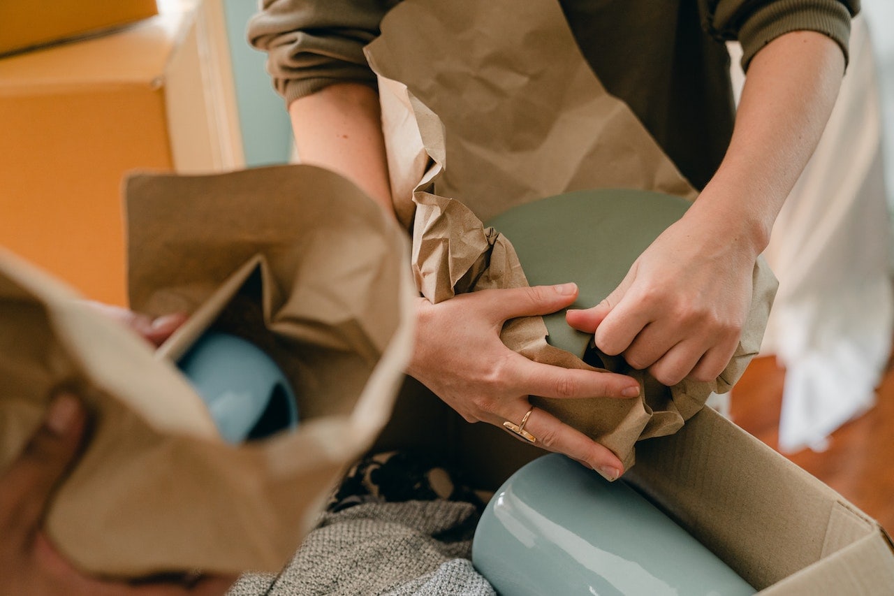 a person packing fragile items with packing paper