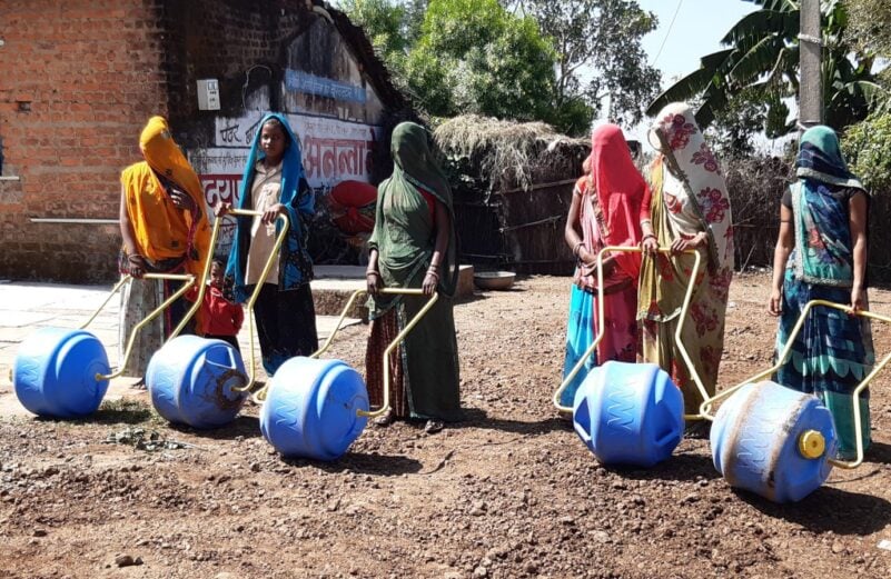 Mujeres acarreando agua en la India con bidón rodante