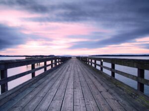 Un antiguo puente de madera al atardecer.