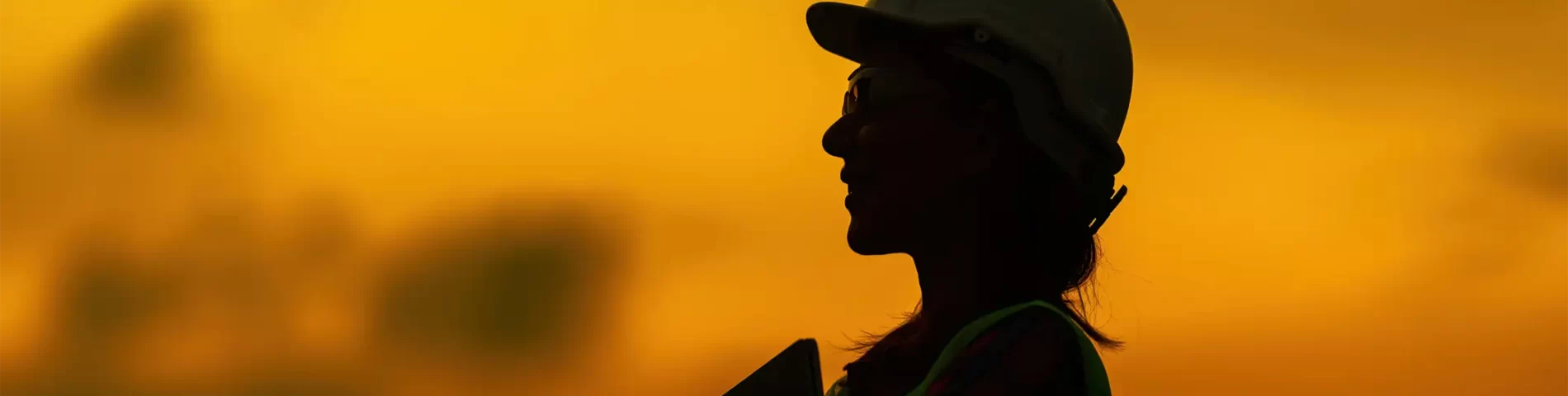 silhouette of female engineer holding laptop