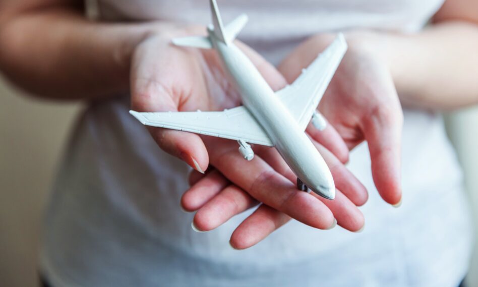 Mujer sosteniendo un avión en miniatura