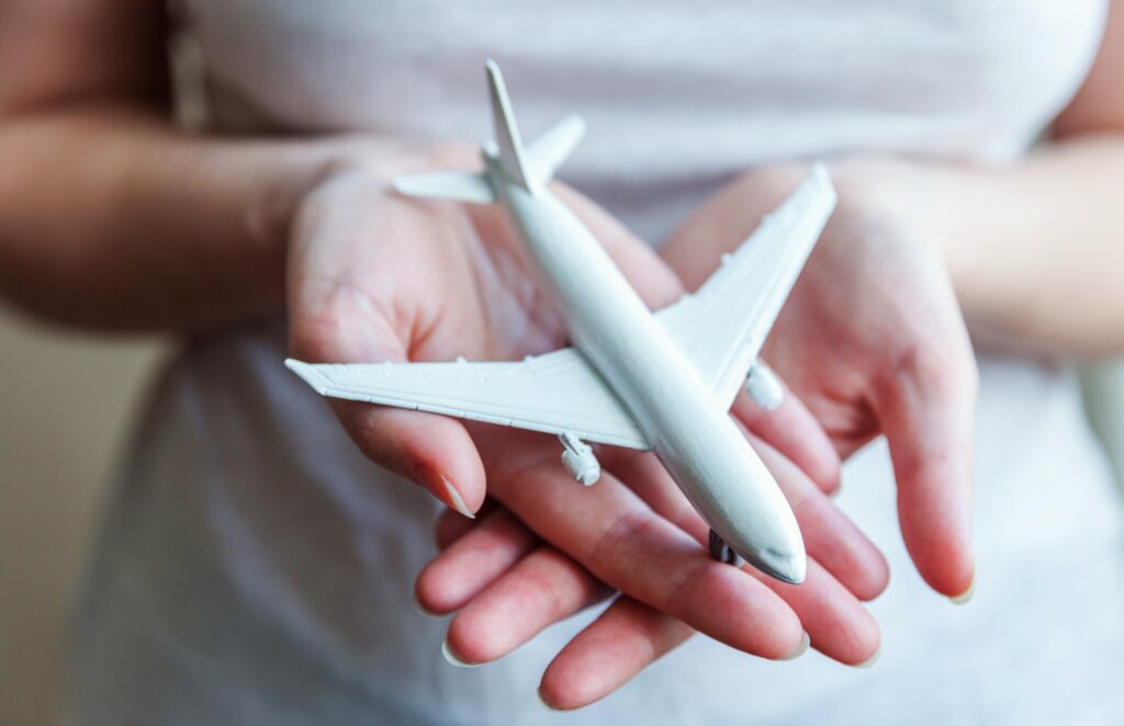 Mujer sosteniendo un avión en miniatura