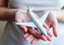Mujer sosteniendo un avión en miniatura
