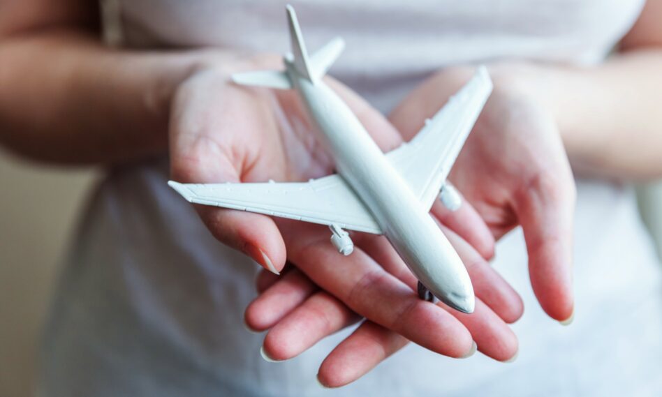 Mujer sosteniendo un avión en miniatura