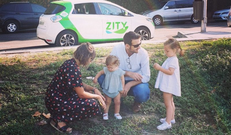 Image of a family with two children in front of a Zity car
