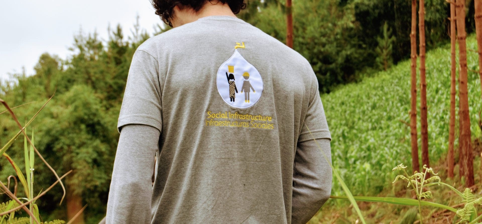 Imagen de un chico de espaldas con una camiseta de Infraestructuras Sociales de Ferrovial