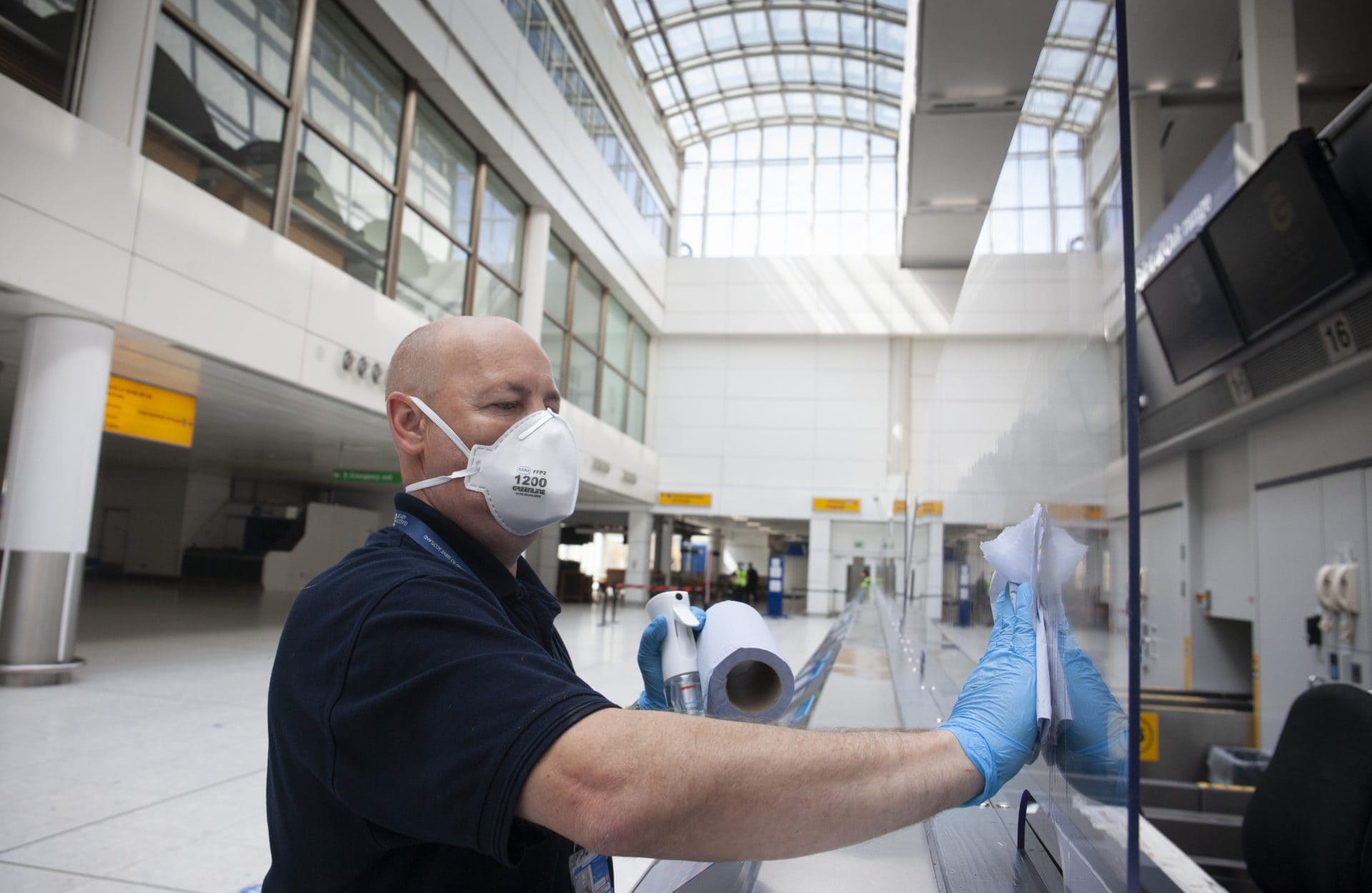 Man cleans Heathrow airport covid 19 measures safety